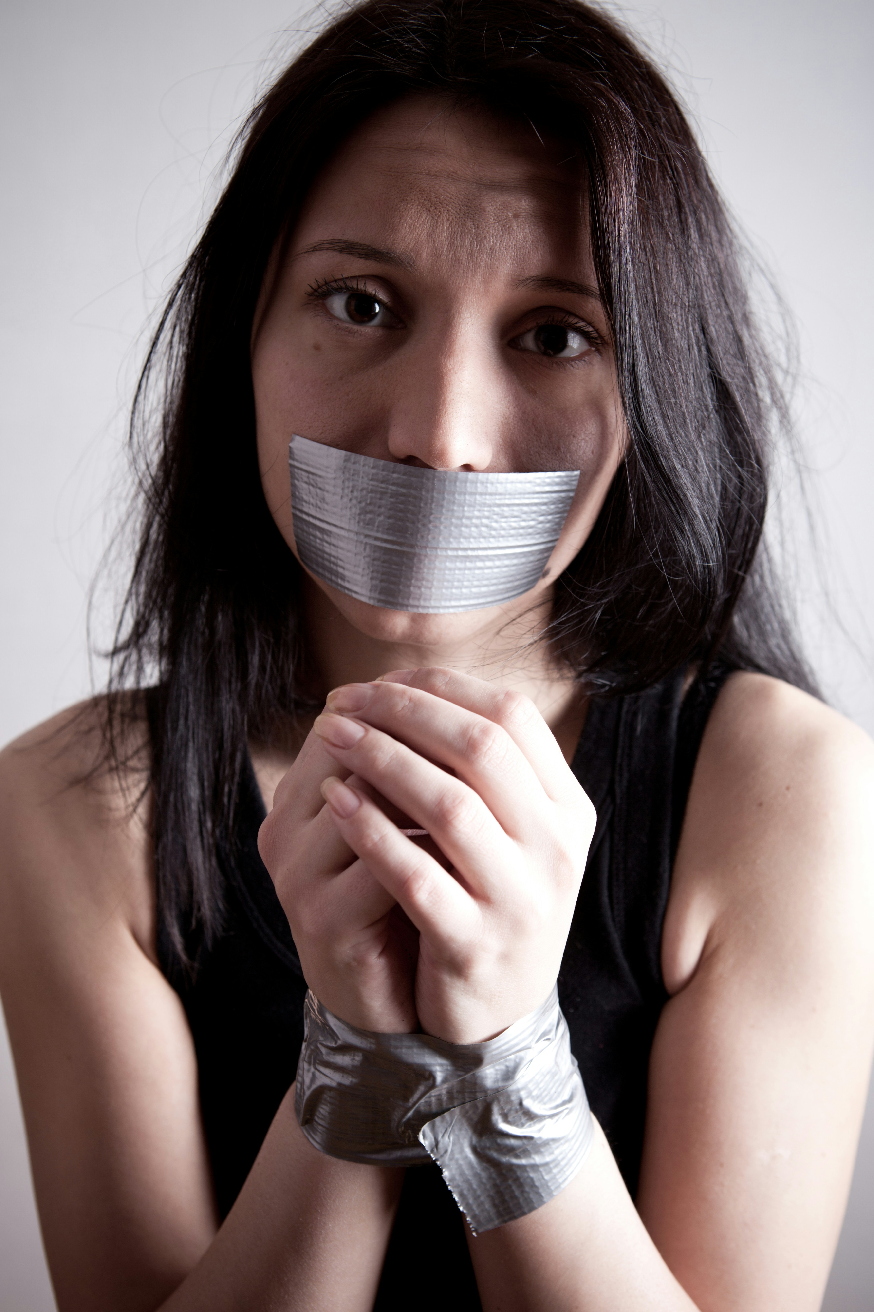 A woman with her mouth covered, symbolizing silence and the inability to speak out